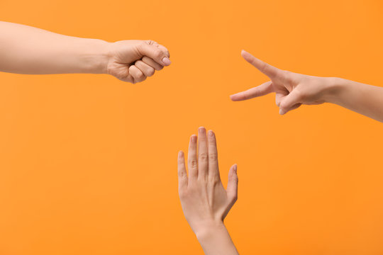 People playing roshambo game on color background