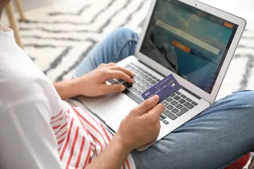 Fotobehang Man with laptop booking tickets online at home © Pixel-Shot