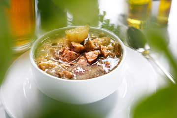 Traditional Polish sour rye soup with sausage and potatoes. Appetizing soup. Suggestion to serve the dish. Culinary photography.