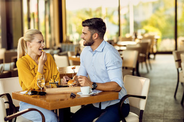 Smiling couple communicating during a lunch in a restaurant.