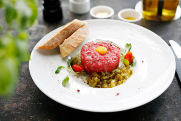 Beef tartare with egg and pickles. Appetizing appetizer. Suggestion to serve the dish. Culinary photography.