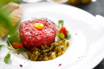 Chopped beef tenderloin, beef tartare with yolk. Appetizing appetizer. Suggestion to serve the dish. Culinary photography.
