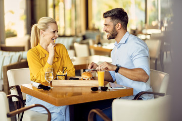 Fototapeta na wymiar Happy couple talking while having lunch in a restaurant.