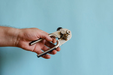 Man's hand holds a can key.