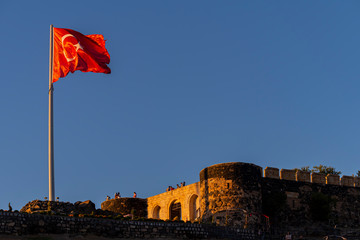 View of Nevsehir Castle at sunset with Turkish flag in Kayasehir