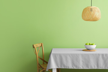 Table and chair near color wall