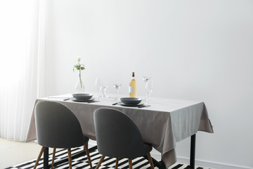 Table and chairs near light wall