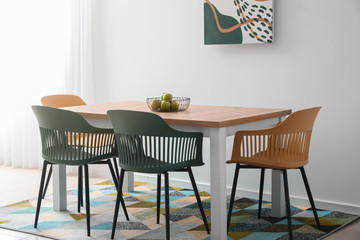 Table and chairs near color wall