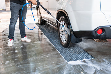 strong man washing car at self carwash outdoors