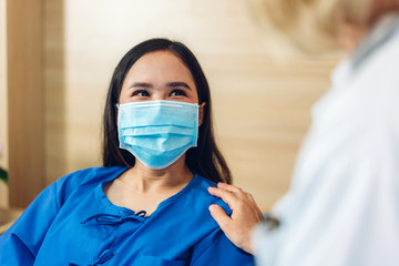 Woman doctor consulting and holding hand patient reassuring with care on doctors table in hospital.healthcare and medicine