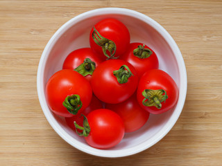 Freshly picked bright red home grown tomatoes, variety Mountain Magic, in a small bowl