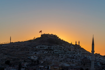 View of Nevsehir Castle at sunset with Turkish flag in Kayasehir