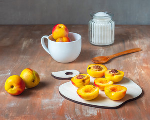 Making homemade jam, cut nectarines in halves and sugar in a glass jar