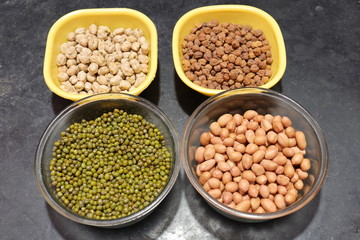 Fresh green gram beans and peanuts with channa dal on black background