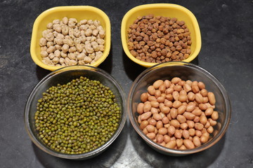 Fresh green gram beans and peanuts with channa dal on black background