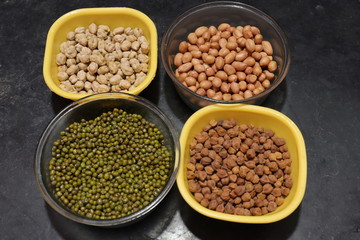 Fresh green gram beans and peanuts with channa dal on black background