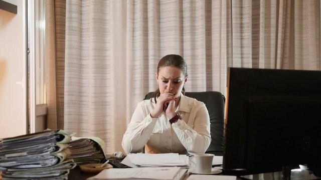 Tired woman working overtime in her office