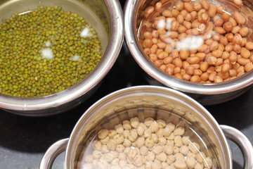 Fresh green gram beans and peanuts with channa dal on black background