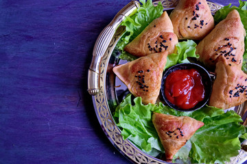 Samsa or Sambousak an oriental meal to be stuffed with minced meat, cheese or vegetables. The national dish of Uzbekistan is samsa with greens. Tasty, healthy, spring dish. Copy space. Top view.