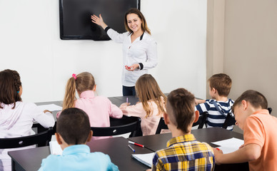 Professor and elementary age children in a classroom at school