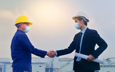 Asian man in face mask hands shake business partnership success on site construction background