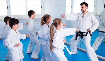 Fototapeta na wymiar Teenagers are repeating for the coach in karate class.