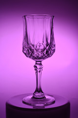Wineglass on the light background. Fine cristal glassware concept. Vertical, toned in pink