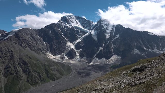 Dongusorun and Nakra-tau from Pik Cheget. Huge mountain snowy peak and glacier "Seven" on a sunny summer day. 