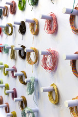 Colored thread hanging on a white wall.