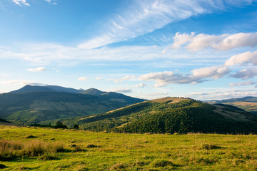 beautiful carpathian countryside. sunny afternoon. wonderful autumn landscape in mountains. rural scenery with agricultural fields on rolling hills. watershed ridge in the distance