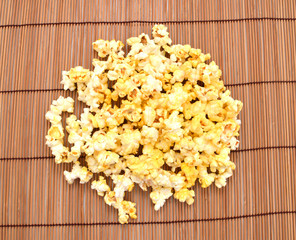 fresh popped popcorn isolated on bamboo mat background