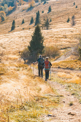 Obraz premium Two old people actively spend weekends in the autumn mountains go to Hiking