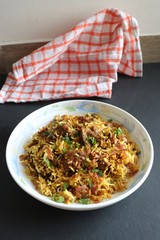 Mutton Biryani or Lamb Pulao. Garnished with fried onion & chopped coriander. Biryani is a famous Spicy non vegetarian dish of India. Goat meat cooked along with Basmati rice & spices.