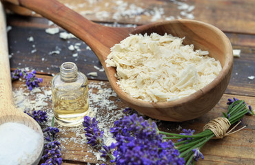 spoon full of flakes of soap with essential oil and bunch of lavender flowers