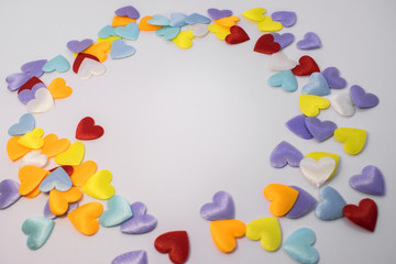 a circle of colorful little hearts. In the center of the circle there is an empty light space for...