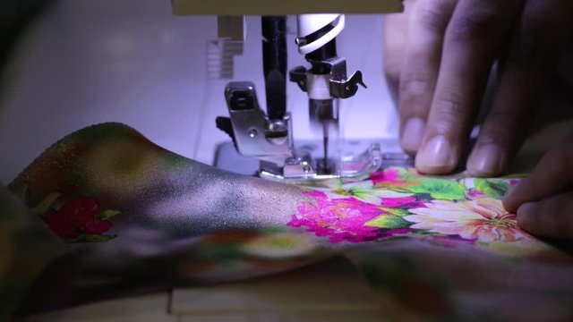Fast and automatic sewing process of a Sewing machine work by a tailoring women and her process b roll clip.