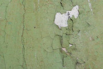 Peeling paint on the wall. Old concrete wall with cracked flaking paint. Weathered rough painted...