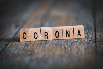 Konzept Corona- das Wort Corona aus mit Holzwürfeln geschrieben auf Holzuntergrund