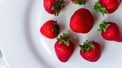  Appetizing fresh strawberries on a white plate. Vegetarian, healthy lifestyle