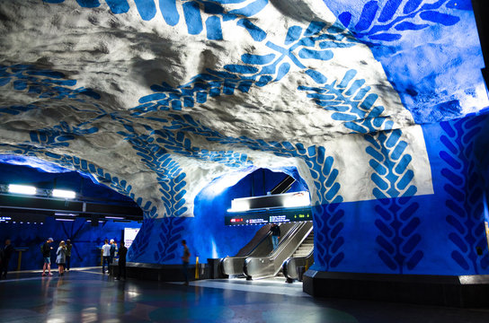 Sweden, Stockholm, May 30, 2018: underground metro tunnelbana station T-Centralen (blue line, central station) with escalator and white blue patterned walls, ceiling and floor - modern art gallery