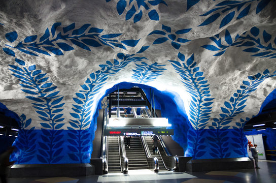 Sweden, Stockholm, May 30, 2018: underground metro tunnelbana station T-Centralen (blue line, central station) with escalator and white blue patterned walls, ceiling and floor - modern art gallery