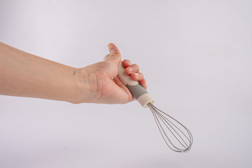 hand holding whisk egg isolated on white background