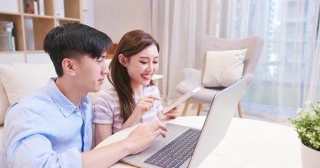 couple discuss finances at home - Powered by Adobe