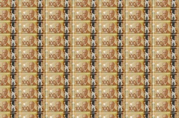 100 Canadian dollars bills printed in money production conveyor. Collage of many bills. Concept of...