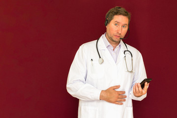 Young caucasian doctor with stethoscope talking with patient online red background