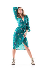Confident sexy woman in green dress modelling and posing with hand on head. Full body length isolated on white background.