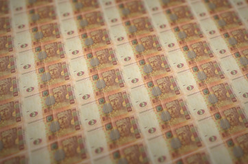 2 Ukrainian hryvnias bills printed in illegal money production conveyor. Collage of many fake...