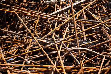 Rusty steel rebar scraps. Stack of rusty iron rods or bars.