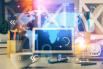 Double exposure of desktop with computer and world map hologram. International data network concept.