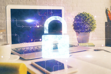 Double exposure of desktop with computer and lock icon hologram. Concept of data safety.